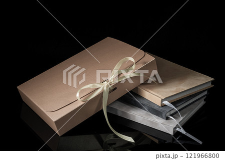 Best gift for men. Man gift concept. Various notebooks with craft gift box black background. Copy space text. Valentine's day, wedding, birthday and special occasion gift concept. Copy space for text. 121966800