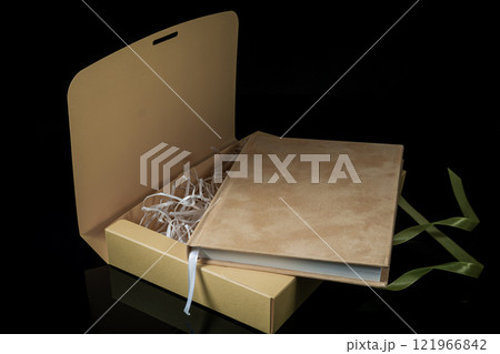 Best gift for men. Man gift concept. Yellow notebook with yellow gift box on black background. Copy space. Valentine's day, wedding, birthday and special occasion gift concept. Copy space for text. Best gift for men. Man gift concept. Yellow notebook with yellow gift box on black background. Copy space. Valentine's day, wedding, birthday and special occasion gift concept. Copy space for text. 121966842