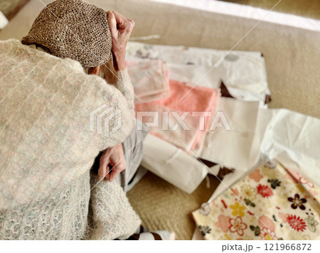 物の前で頭を抱える高齢女性 121966872