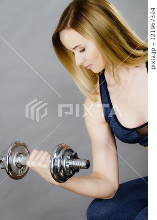 Fit woman lifting dumbbells weights 121967394
