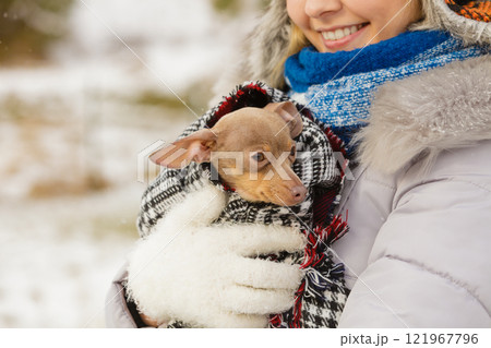 Woman hug warming her little dog in winter 121967796
