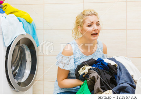 Unhappy girl with dirty clothes laundry. 121967816