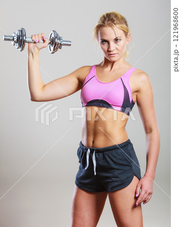 Fit woman lifting dumbbells weights Fit woman lifting dumbbells weights 121968600