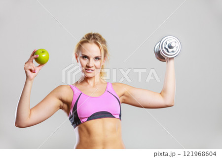 Diet fit body. Girl holds dumbbells and apple fruit Diet fit body. Girl holds dumbbells and apple fruit 121968604
