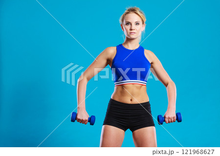 Fit woman lifting dumbbells weights 121968627