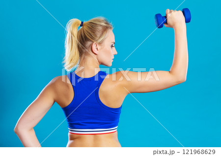 Fit woman lifting dumbbells weights Fit woman lifting dumbbells weights 121968629