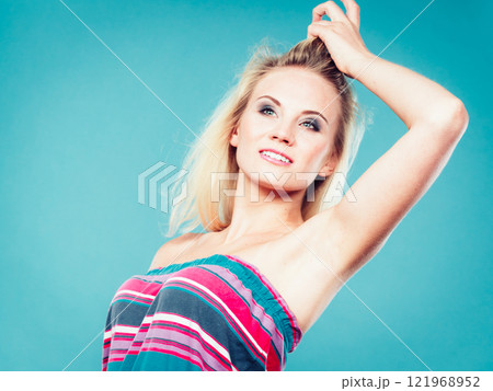 Blonde woman wearing colorful striped strapless shirt 121968952