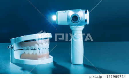 A dental tool is next to a model of a tooth A dental tool is next to a model of a tooth 121969784