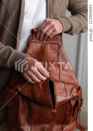 A Stylish and Professional Man Standing with a yellow brown backpack 121969883