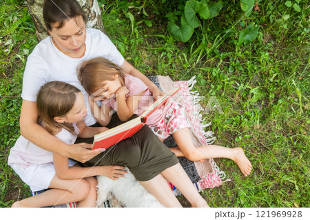 Family enjoying storytime together on a summer day Family enjoying storytime together on a summer day 121969928