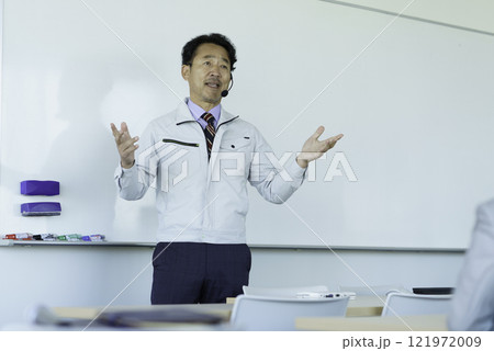 ホワイトボードの前で話をする作業服のミドルエイジの男性 撮影協力:学校法人電波学園 東京電子專門学校 ホワイトボードの前で話をする作業服のミドルエイジの男性 撮影協力:学校法人電波学園 東京電子專門学校 121972009