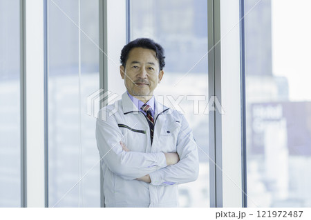 オフィスの窓の前に立つ作業服のミドルエイジの男性 撮影協力:学校法人電波学園 東京電子專門学校 オフィスの窓の前に立つ作業服のミドルエイジの男性 撮影協力:学校法人電波学園 東京電子專門学校 121972487