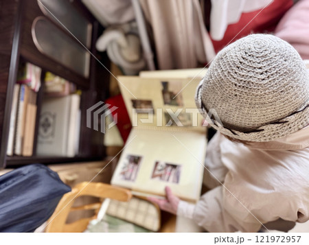 散らかった部屋でアルバムを見る高齢女性_上から 121972957