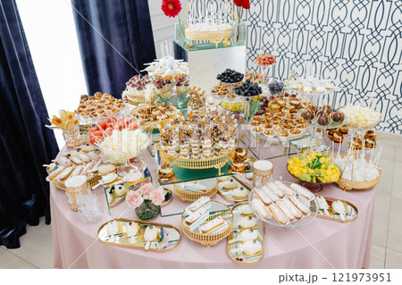 Catering service presenting delicious desserts and fruits on a table Catering service presenting delicious desserts and fruits on a table 121973951