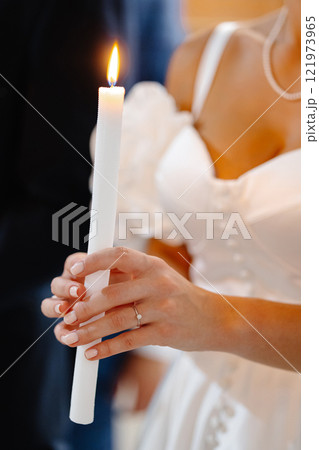 Bride holding burning candle during wedding ceremony Bride holding burning candle during wedding ceremony 121973965