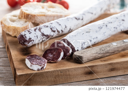 Fuet.Dry cured fuet sausage on wooden table 121974477