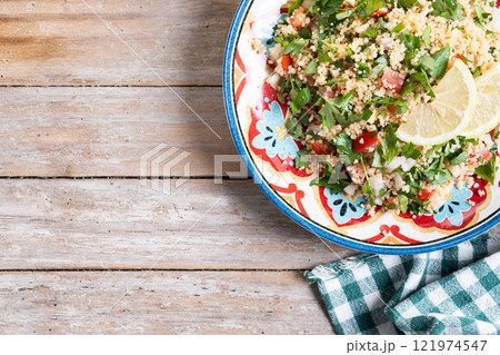 Tabbouleh salad with couscous on wooden table Tabbouleh salad with couscous on wooden table 121974547