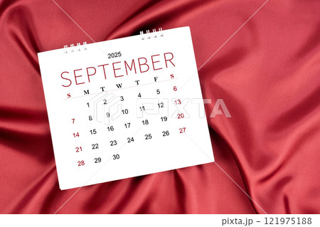 September 2025 Monthly desk calendar on red silk textile background. September 2025 Monthly desk calendar on red silk textile background. 121975188