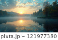 Beautiful sunrise over tranquil lake surrounded by trees on a misty morning 121977380