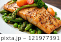 Grilled salmon served on a bed of fresh asparagus and green peas with cherry tomatoes 121977391