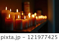 Flickering candles illuminate a peaceful setting in a dimly lit room during evening hours 121977425