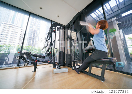 ジムで筋トレしている女性、Woman doing muscle training ジムで筋トレしている女性、Woman doing muscle training 121977852