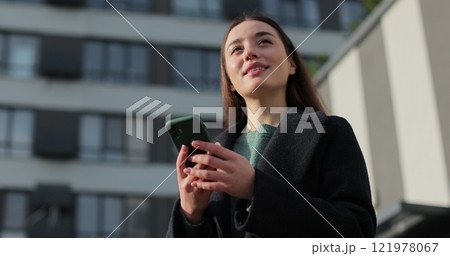 Young beautiful woman smiling confident using smartphone at street. Smartphone browsing internet, searching, reading news in social media. 121978067