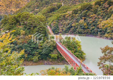 川根本町の秋の紅葉に染まる奥大井湖上駅の奥大井レインボーブリッジの風景(静岡県) 121978550