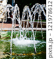 Vertical jets of water from the fountain. Close-up view. Jets flowing out of the fountain. Summer urban landscape 121978612