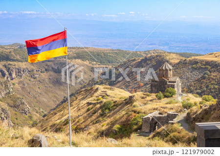 Aerial drone view to flag of Armenia and famous Vahramashen Church of the 11th century, near Amberd fortress in sunny summer day. Cliff with Arkashian River deep in canyon. Aragatsotn region, Armenia Aerial drone view to flag of Armenia and famous Vahramashen Church of the 11th century, near Amberd fortress in sunny summer day. Cliff with Arkashian River deep in canyon. Aragatsotn region, Armenia 121979002