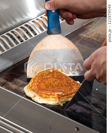 Cooking fresh pancake on black pan 121979549