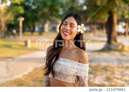 Woman in the park smiling with eyes closed 121979661