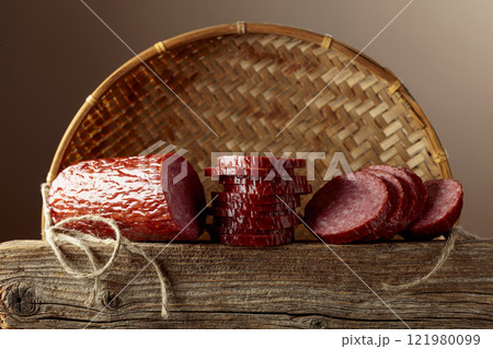 Sliced salami on a old wooden board. 121980099