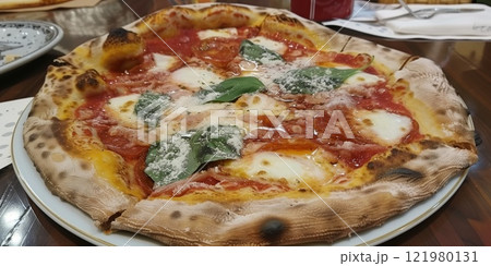 Traditional margherita pizza with a wood-fired crust, topped with fresh mozzarella, tomato sauce, basil, and parmesan cheese, served on a ceramic plate 121980131
