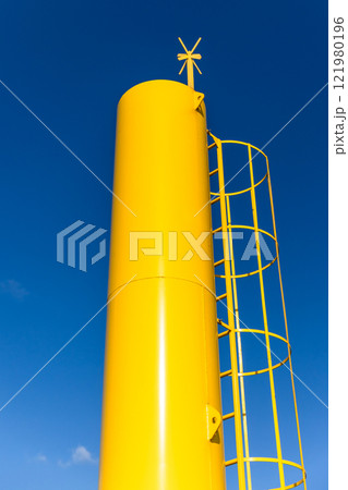 Yellow navigation tower with cross shaped top mark 121980196