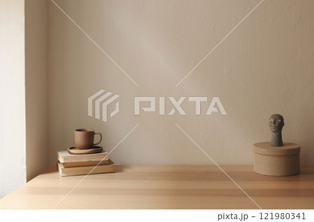 Artistic boho still life. Cup of tea, coffee, old books. Boho busta sculpture, statue. Round textile gift box. Beige wall background mockup. Empty copy space. Elegant minimal interior living room. 121980341