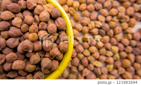 Brown or Black Chickpeas (Kala Chana) Top View in a Yellow Bowl with Scattered Background Brown or Black Chickpeas (Kala Chana) Top View in a Yellow Bowl with Scattered Background 121981694