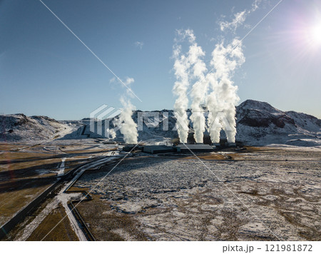 White steam billows from the geothermal power plant in Hellisheidi, Iceland, contrasting with the snowy peaks of Iceland's breathtaking winter scenery in this aerial White steam billows from the geothermal power plant in Hellisheidi, Iceland, contrasting with the snowy peaks of Iceland's breathtaking winter scenery in this aerial 121981872