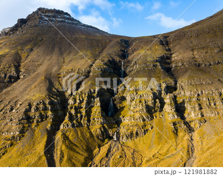 Majestic krossfoss waterfall flowing down a steep, rocky mountainside in the icelandic highlands, showcasing the raw beauty of nature 121981882