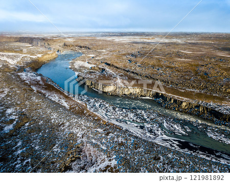 Aerial of the snowy volcanic landscape, showcasing the majestic Dettifoss waterfall in Iceland in a breathtaking view from above 121981892