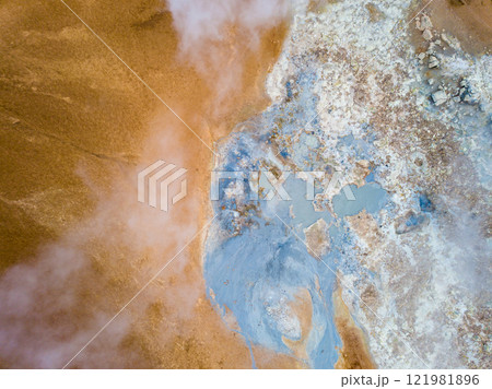 Steam billows from the geothermal area of Hverir near the Kafla vulcanic area of Iceland, highlighting vibrant mineral deposits in the foreground against a striking landscape Steam billows from the geothermal area of Hverir near the Kafla vulcanic area of Iceland, highlighting vibrant mineral deposits in the foreground against a striking landscape 121981896