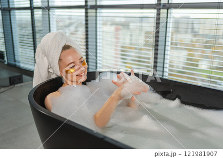 Spa relaxation. Young woman lying in bath with foam bubbles. Girl relaxing in bathroom at home. Pretty female spending morning in bathroom enjoying taking bath. Beauty treatment body skin care concept Spa relaxation. Young woman lying in bath with foam bubbles. Girl relaxing in bathroom at home. Pretty female spending morning in bathroom enjoying taking bath. Beauty treatment body skin care concept 121981907