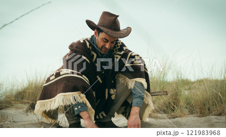 Man digs with his hands in the sand 121983968