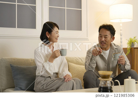 夜のリビングで会話する熟年夫婦 夜のリビングで会話する熟年夫婦 121985306