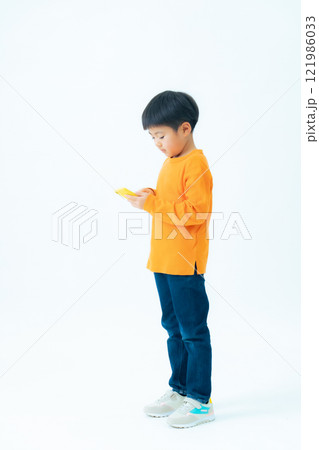 スマホを使う男の子の全身写真 スマホを使う男の子の全身写真 121986033