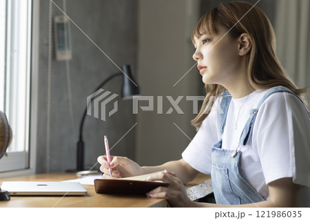 机に向かう女性 121986035