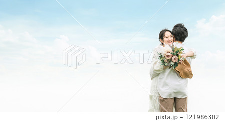 草原の中のカジュアルウェディング・カップル・恋人・夫婦のイメージ 121986302