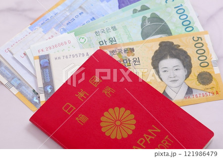 韓国の通貨、ウォンKRWの紙幣と、パスポート(一般旅券10年用赤色)で、韓国旅行のイメージ 韓国の通貨、ウォンKRWの紙幣と、パスポート(一般旅券10年用赤色)で、韓国旅行のイメージ 121986479