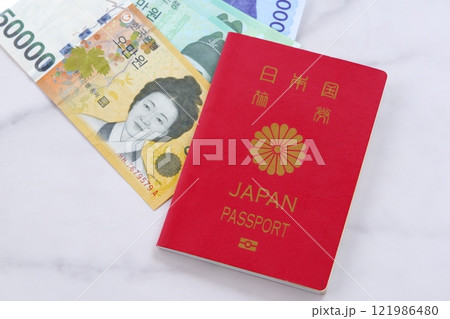 韓国の通貨、ウォンKRWの紙幣と、パスポート（一般旅券10年用赤色）で、韓国旅行のイメージ 121986480
