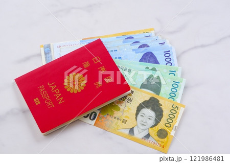 韓国の通貨、ウォンKRWの紙幣と、パスポート(一般旅券10年用赤色)で、韓国旅行のイメージ 韓国の通貨、ウォンKRWの紙幣と、パスポート(一般旅券10年用赤色)で、韓国旅行のイメージ 121986481